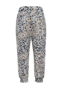 Lätta joggers i en beige tyg med ett flerfärgat prickigt mönster, elastisk midjeband och åtsittande muddar vid anklarna.