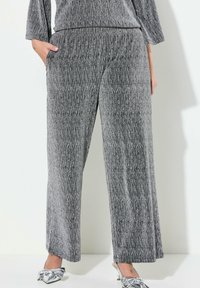 Grijze, gestructureerde wijde broek met een verticale streepjespatroon. Voorzien van een elastische tailleband en zijzakken, gemaakt van een zachte stoffenmix.