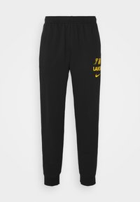 Sorte fleece joggebukser med ribbede anklumer. Har gul Nike-logo og "LAKERS" tekst på venstre side. Elastisk midjebånd for komfort.