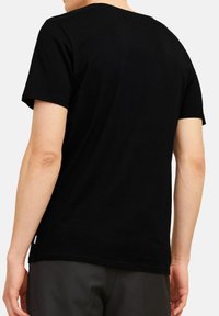 Sort kortærmet t-shirt lavet af bomuld, med en klassisk rund halsudskæring. Glat tekstur uden synlige mønstre. Lille mærke ved kanten.