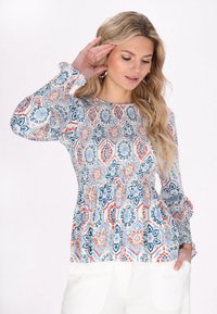 Langærmet bluse i let materiale med et flerfarvet blomster- og geometrisk mønster, med en smocket talje og flæser ved ærmerne.