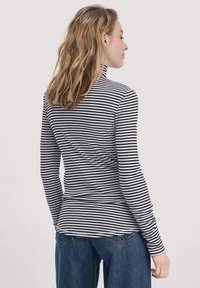 Langärmliges Turtleneck-Oberteil mit navyblauen und weißen horizontalen Streifen, aus weichem Stoff gefertigt. Verfügt über eine taillierte Form und einen umgeschlagenen Saum.