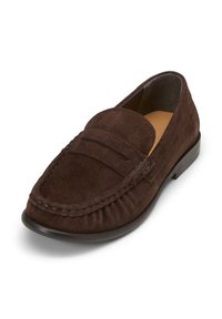 Braune Wildleder-Loafer mit einem genähten Mokassin-Design, abgerundetem Zehenbereich und einer flachen Gummisohle. Minimalistische Ästhetik und glatte Textur.