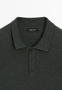 Mørkegrå ribbet strik polo med krave og tre sorte knapper, mærket Massimo Dutti, lavet i Kina.