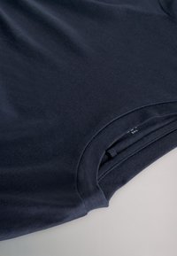 Navy blue cotton t-shirt featuring a round neckline and short sleeves, with a smooth texture and a side tag visible near the hem.