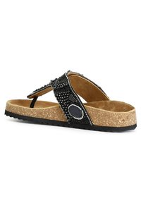 Tongs noires ornées, avec une semelle en liège, une bride noire texturée avec des détails en perles et une semelle en caoutchouc pour une meilleure adhérence.