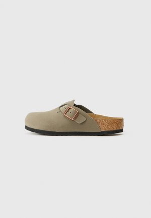 Maslinasto zelene klompe s teksturiranim gornjim dijelom, podesivim kopčanjem i plutastom uloškom, s crnim gumenim potplatom za bolji grip.