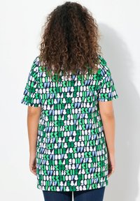 Korte mouwen shirt met een geometrisch patroon van groene, blauwe en witte vormen op een zwarte achtergrond, gemaakt van lichtgewicht stof.