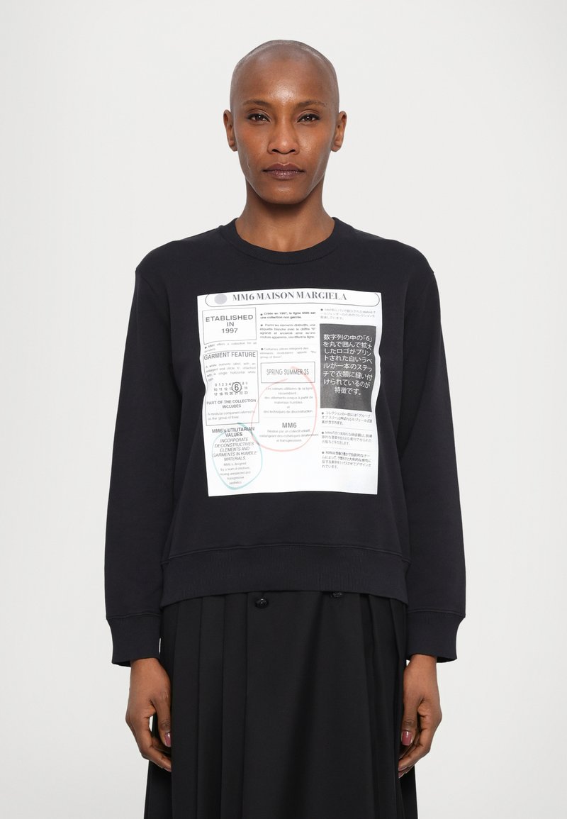 Μαύρο sweatshirt με στρογγυλή λαιμόκοψη, που διαθέτει ένα μεγάλο γραφικό σχέδιο στο μπροστινό μέρος που περιλαμβάνει κείμενο και πολύχρωμες κύκλους.