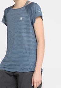 Sininen urheilut-paita lyhyillä hihoilla, jossa on raidallinen kuvio ja pieni logo rinnassa. Kevyt, hengittävä materiaali.