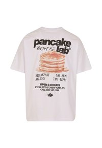 Tricou alb din bumbac, cu un grafic mare de clătite și text care promovează „Pancake Lab”, cu informații despre program și locație.