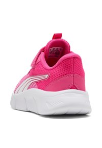 Pink athletic shoe with a textured mesh upper, white accents, a hook-and-loop strap, and a flexible white sole. Rear view, showcasing heel design.