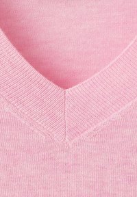 Różowy sweter z dekoltem w serek o delikatnej teksturze. Posiada prążkowany dekolt oraz lekko melanżowe wykończenie, podkreślające miękkość i ciepło.