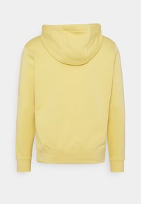 Sudadera amarilla hecha de un tejido suave, con una gran capucha ajustable y puños de canalé, con un diseño simple y limpio sin patrones visibles.