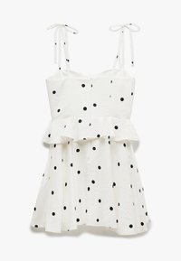 Biała sukienka w czarne kropki, z peplum w talii, cienkimi ramiączkami i teksturowanym materiałem. Sylwetka w kształcie litery A z rozkloszowaną spódnicą.