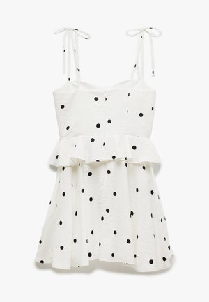 Vestido blanco con lunares negros, con cintura peplum, finas tiras en los hombros y tejido texturizado. Silueta en A con una falda acampanada.