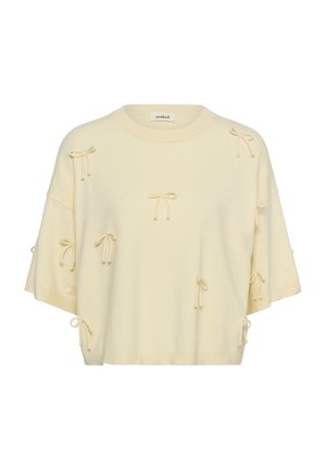 Džemper kratkih rukava krem boje s više malih ukrasnih mašnica i okruglim izrezom na vratu.