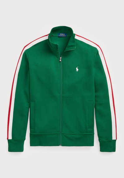Giacca verde con zip realizzata in tessuto morbido. Presenta accenti a strisce bianche e rosse sulle maniche e un piccolo logo ricamato sul petto.