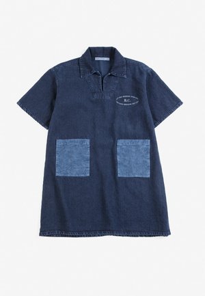 Robe en jean bleu foncé à manches courtes avec col, deux poches avant bleu clair et petit texte blanc sur la partie supérieure gauche de la poitrine.