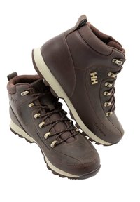 Botas de senderismo de cuero marrón con cuellos acolchados, ojales metálicos y suelas resistentes. Presentan acentos compuestos y un acabado texturizado.