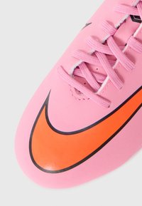 Crampon de football synthétique rose avec lacets, un grand logo swoosh orange, et une surface lisse et texturée avec un design épuré.