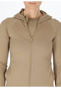 Beige Kapuzenjacke mit Reißverschluss und gerippter Textur, ausgestattet mit einem hohen Kragen und Raglanärmeln. Goldener Reißverschluss entlang der Vorderseite.