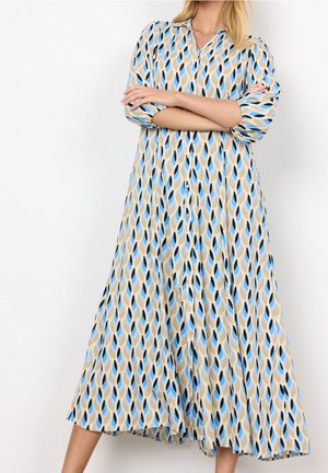 Lange jurk met een bladmotief in blauw, beige en zwart. Gemaakt van lichtgewicht stof met een V-hals en knoopsluitingen.