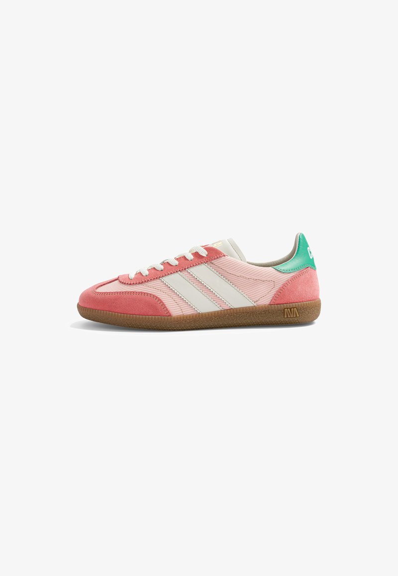 Sneaker profil bas en mesh rose et suède, bandes latérales blanches, languette de talon verte, lacets blancs et semelle en caoutchouc marron sur fond blanc.