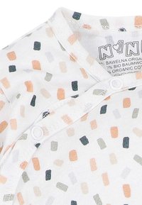 Witte baby romper met veelkleurige rechthoekige vlekken in oranje, grijs en zwart, met drukknoopjes aan de voorkant.