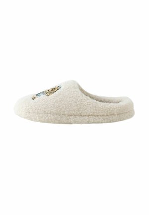 Fuzzy cream-colored slipper with a soft texture, round shape, and embroidered lion design on the front. No visible hardware or accents.