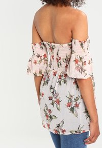 Top floreale off-the-shoulder con corpetto arricciato, maniche corte a palloncino, tessuto rosa chiaro, con motivi di fiori multicolori.