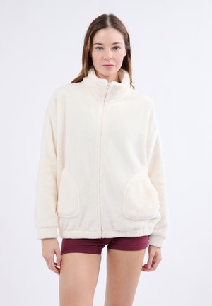 Giacca in pile zip-up color crema, con colletto alto, due tasche frontali e vestibilità morbida con polsini e orlo a costine.