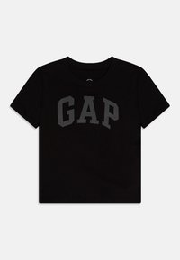 Melnā īsajās piedurknēs t-kreklā, kas izgatavots no kokvilnas, uz krūšu ir liels pelēks "GAP" teksta logotips. Vienkāršs dizains, regulāra piegriezuma.