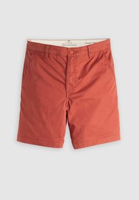 Chino shorts väri rauta-oranssi, litteällä etuosalla, kahdella sivutaskulla, yhdellä takataskulla ja vyölenkeillä, valmistettu sileästä puuvillakankaasta.