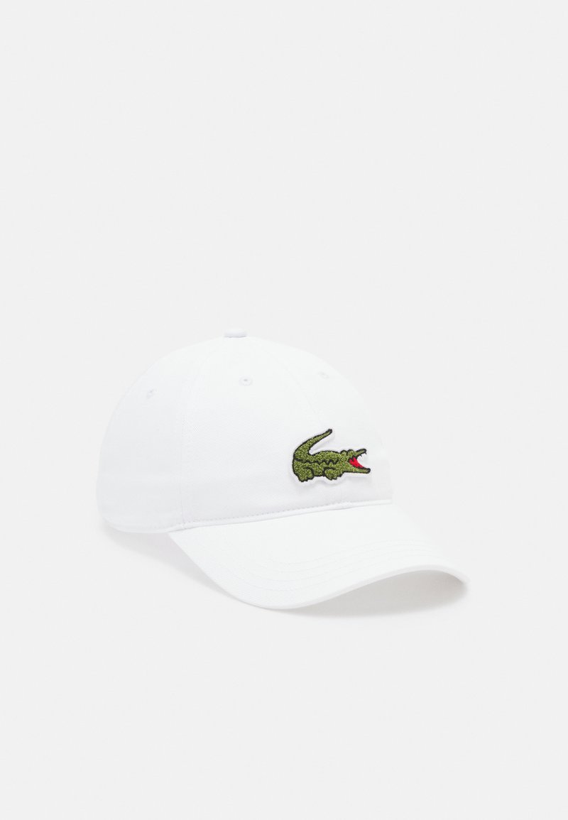 Capa de basebol branca em algodão com uma aba curva e o logotipo de jacaré verde bordado na frente. Apresenta seis orifícios de ventilação.