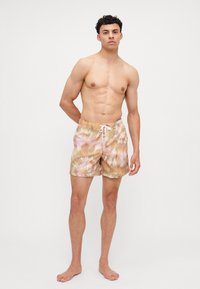 Schwimmshorts mit einem Batikmuster in Pastellfarben. Sie verfügen über einen elastischen Bund und eine Kordel, hergestellt aus einem leichten Stoff.