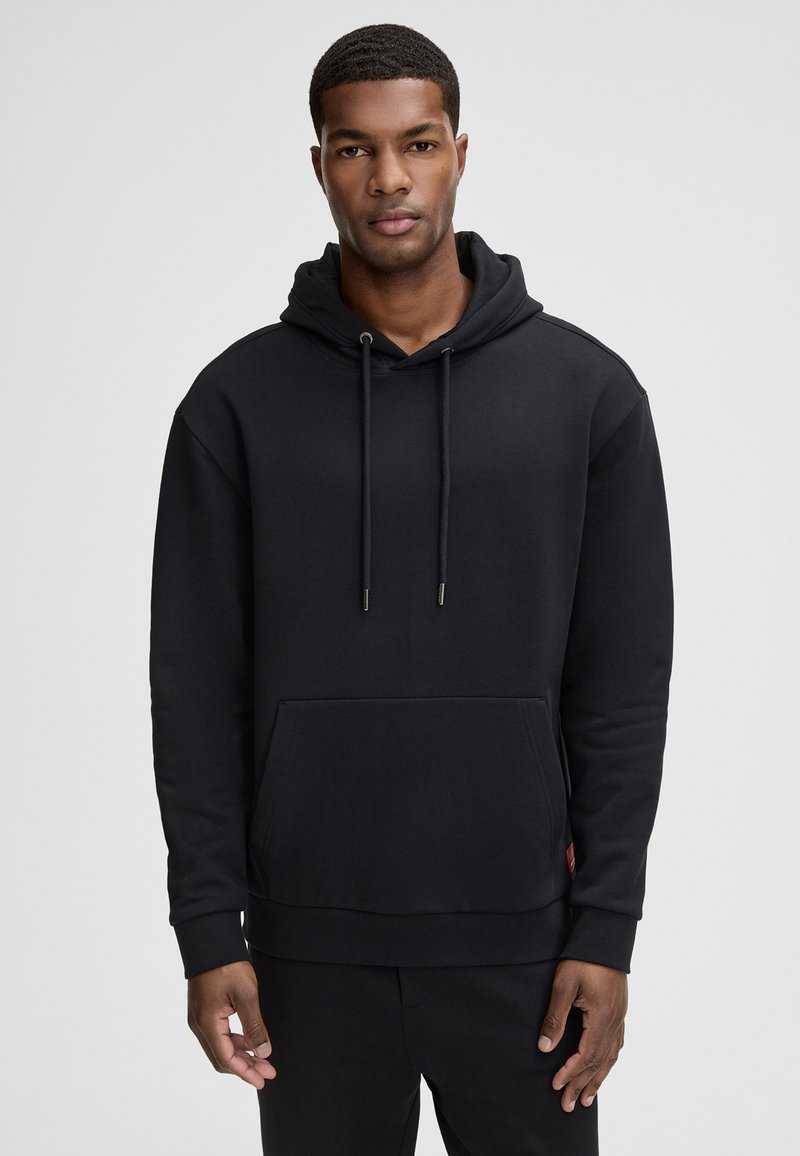 Felpa nera con cappuccio, dettagli con cordoncino, tasca kangaroo frontale, polsini e orlo a coste. Tessuto liscio con un design semplice.