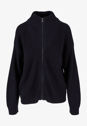 Pull en maille zippé de couleur bleu marine foncé avec un col montant, une texture côtelée et des épaules tombantes. La fermeture éclair se situe sur le devant.