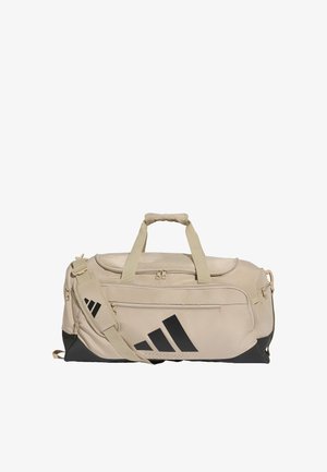 Beige ja musta urheilukassi, jossa on kaksinkertaiset kantokahvat, säädettävä olkahihna, etutasku vetoketjulla ja näyttävä musta Adidas-logo.