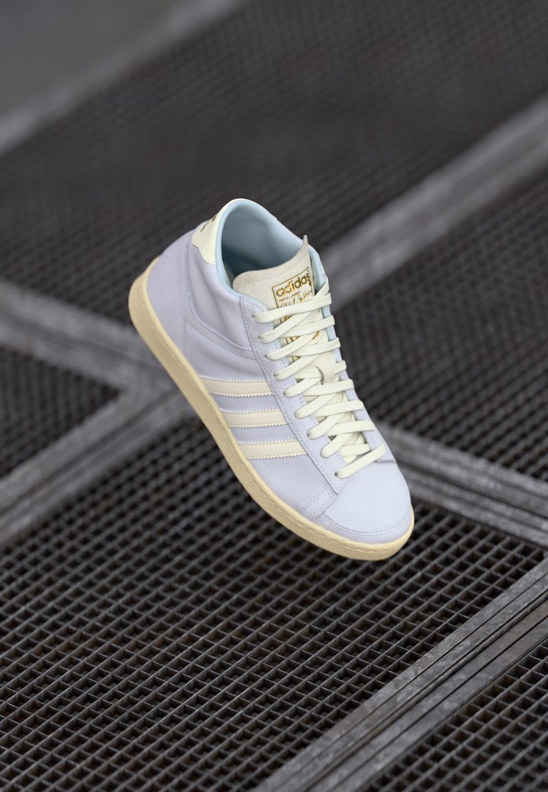 Ljusblå hög sneaker i slät läder med en mjuk inredning, tonmatchande snören och tre vita sidostripor. Mjuk beige sula.