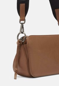 Braune Leder-Crossbody-Tasche mit schwarzem Stoffriemen, silberner Metallschließe und Reißverschlussdetail, geprägt mit dem „Liebeskind Berlin“-Logo.