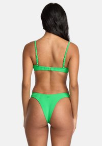Bikini verde a righe con spalline regolabili, caratterizzato da un design minimalista. La texture è a motivo, che mostra un tessuto liscio e elastico.