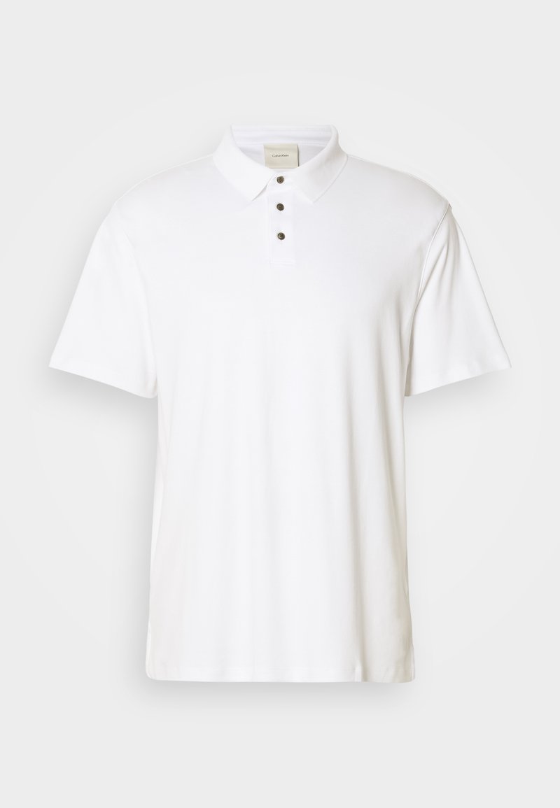 Polo shirt blanc en coton, avec un col classique, des manches courtes et une patte de boutonnage à trois boutons. Texture lisse, sans motifs ni accents.