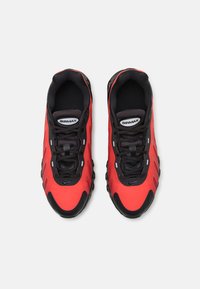 Baskets à tige en maille rouge et synthétique avec des accents, des lacets et une semelle rembourrée noirs. Présente un patch logo sur la languette.