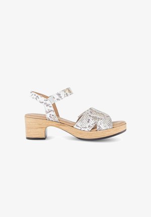 Witte en grijze sandaal met slangenhuidpatroon, open teen, lage blokhak van hout en verstelbare enkelband.