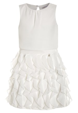 Witte mouwloze jurk met een zachte lijfje en een gelaagde ruchesrok, met een kleine zilveren bedel nabij de taille.