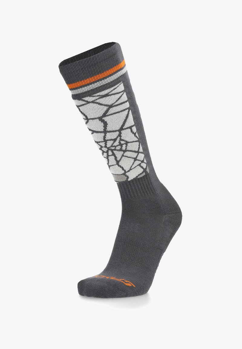 Chaussette grise haute jusqu'au genou avec un motif géométrique blanc, présentant une bande orange en haut. Fabriquée à partir d'un matériau doux et extensible pour un maximum de confort.