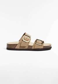 Sandales en suede marron avec deux larges brides ornées de boucles en métal carrées, une semelle intérieure en liège texturé et une épaisse semelle en caoutchouc noir à motif.