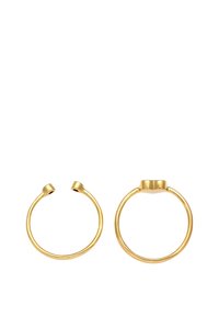 Anelli in metallo color oro, uno aperto e rotondo, l'altro con una piccola parte superiore piatta. Superficie liscia e lucida con design minimalista.