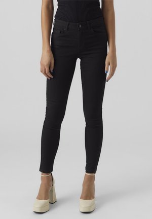Black skinny jeans made of stretchy denim, featuring a high waist, five-pocket design, and a sleek, smooth texture.